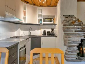 a kitchen with a table and a stone fireplace at Holiday Home Luppokero 1 by Interhome in Pyhätunturi