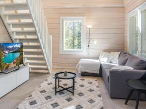 a living room with a couch and a tv at Holiday Home Kitkanvee 1 by Interhome in Kuusamo