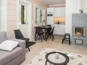 a living room with a couch and a fireplace at Holiday Home Kitkanvee 1 by Interhome in Kuusamo