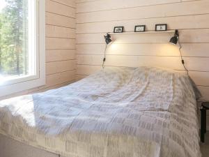 a bedroom with a bed with two pictures on the wall at Holiday Home Kitkanvee 1 by Interhome in Kuusamo