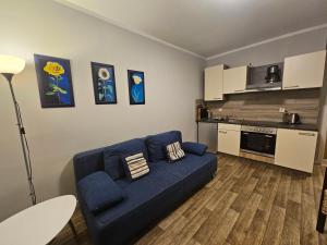 a living room with a blue couch and a kitchen at 08 Heuwiese - Hof Wiesengrund in Parchtitz
