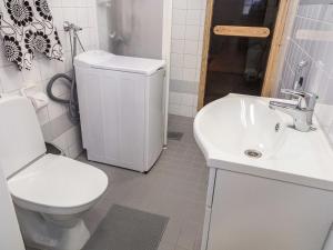 a white bathroom with a toilet and a sink at Holiday Home Point vale 3 by Interhome in Tahkovuori