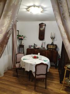 a dining room with a table and chairs and a clock at Iasskii Torg - La belle epoque in Iaşi