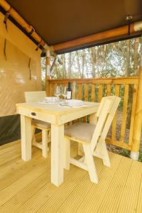 a wooden table and chair sitting on a porch at Glamping Il Poderino in Cecina