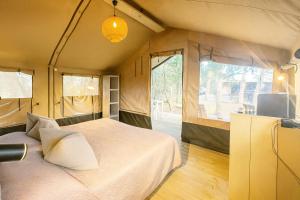 a bedroom with a bed and a tv in it at Glamping Il Poderino in Cecina