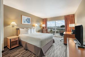 a hotel room with a bed and a flat screen tv at Glen Lyon Inn in Port Hardy