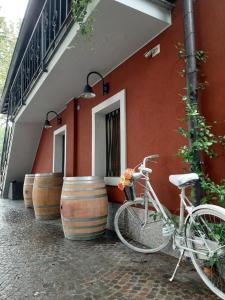 a bike parked next to a building with wine barrels at Osteria Al Ponte in Udine