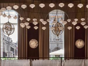 a bunch of chandeliers hanging from a ceiling at Sofitel London St James in London