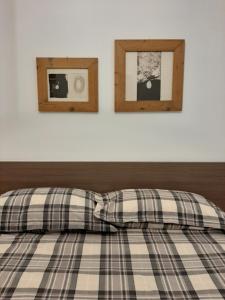 a bed with two pictures on the wall at Osteria Al Ponte in Udine