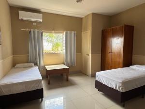 a bedroom with two beds and a window at Hotel Executive Uberaba in Uberaba