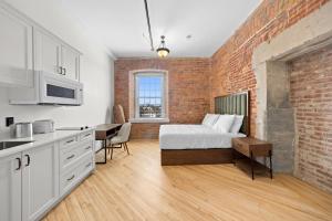 a bedroom with a bed and a brick wall at Tri Century Mill Suites in Carleton Place