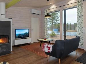 a living room with a fireplace and a television at Holiday Home Jolmalompolo by Interhome in Raanujärvi