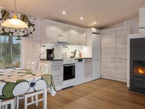 a kitchen and dining room with a table and a fireplace at Holiday Home Jolmalompolo by Interhome in Raanujärvi +15 photos