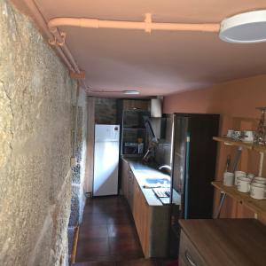 a small kitchen with a refrigerator and a counter at casa cristimil -san amaro in Salamonde