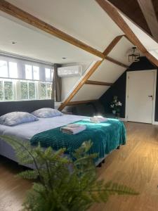 a bedroom with a bed with a green blanket at Fuchsiahoeve in Blaricum