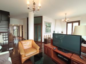 a living room with a flat screen tv and a chair at Suite Dream in Stresa