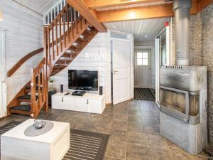 a living room with a staircase and a fireplace at Holiday Home Arha by Interhome in Äkäslompolo