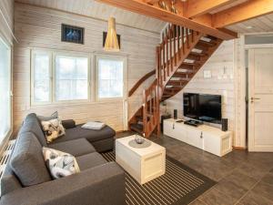 a living room with a couch and a television at Holiday Home Arha by Interhome in Äkäslompolo