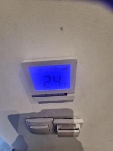 a clock on a wall with a clock on it at COni sobe Kragujevac in Kragujevac