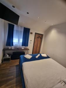 a bedroom with a bed with two towels on it at COni sobe Kragujevac in Kragujevac