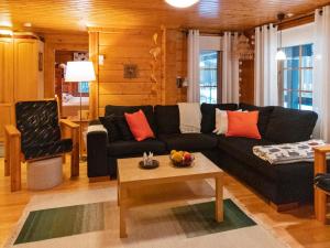a living room with a black couch and a table at Holiday Home Kuusenkolo by Interhome in Pyhätunturi