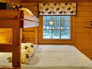 a bedroom with a bed in a log cabin at Holiday Home Kuusenkolo by Interhome in Pyhätunturi +7 photos