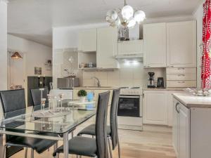 a kitchen with a glass table and black chairs at Holiday Home Huvikumpu by Interhome in Hailuoto