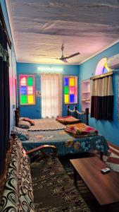 zwei Betten in einem Zimmer mit Buntglasfenstern in der Unterkunft Hotel Paramount Palace in Pushkar