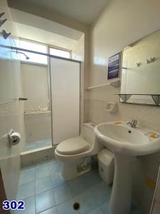 a bathroom with a toilet and a sink at HOSTAL HOGAR 3 Estrellas - CHEPÉN in Chepén