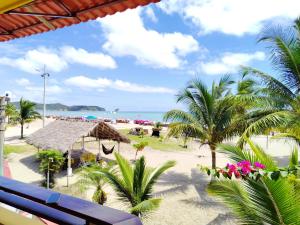 a view of a beach with palm trees and the ocean at Hotel Cielo Azul in Atacames