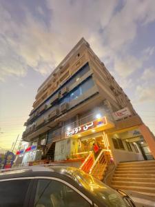 a building with a car parked in front of it at Cloud pyramids view inn in ‘Ezbet `Abd el-Ḥamîd
