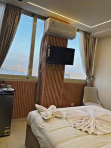 a hotel room with a bed and a flat screen tv at Cloud pyramids view inn in ‘Ezbet `Abd el-Ḥamîd +46 photos
