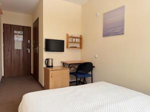 ein Hotelzimmer mit Bett, Schreibtisch und Fernseher in der Unterkunft Luxhostel24 Warsaw in Warschau