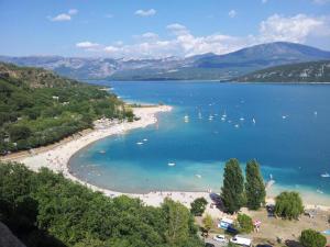 a view of a beach with boats in the water at Appartement avec vue sur le Lac in Sainte-Croix-de-Verdon