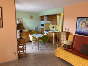 a living room with a couch and a kitchen with a table at Appartement avec vue sur le Lac in Sainte-Croix-de-Verdon
