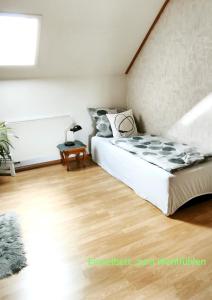 a bedroom with a bed and a wooden floor at Gästewohnung Urfttalsperre in Schleiden