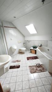 a bathroom with a tub and a toilet and a sink at Gästewohnung Urfttalsperre in Schleiden +32 photos