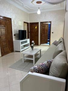 a living room with a couch and a tv at Spacious Family Apartment in Er Rachidia