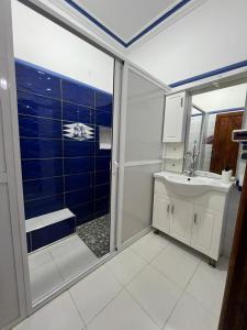 a bathroom with a shower and a sink and a mirror at Spacious Family Apartment in Er Rachidia