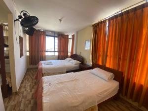 a hotel room with two beds and a window at HOSTAL HOGAR 3 Estrellas - CHEPÉN in Chepén