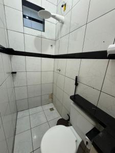 a white bathroom with a toilet and a window at AP 06 - Apartamento Estudio completo in Balsas
