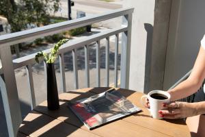 a woman sitting at a table with a cup of coffee at Mint House Tampa Downtown by Kasa in Tampa