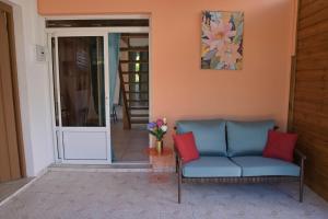 ein Wohnzimmer mit blauem Sofa und roten Kissen in der Unterkunft Sikriyé in Petit-Bourg