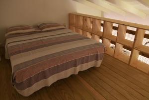 ein Schlafzimmer mit einem Bett mit Holzböden und Fenstern in der Unterkunft Sikriyé in Petit-Bourg + 1 Foto