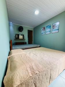 a bedroom with a bed in a room with a microwave at Sol e Sal Suítes Aconchegantes in Saquarema