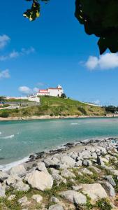 a view of a beach with rocks in the water at Sol e Sal Suítes Aconchegantes in Saquarema +10 photos