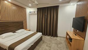 a bedroom with a bed and a flat screen tv at بيان للاجنحة الفندقية - سوق الخوير in Muscat