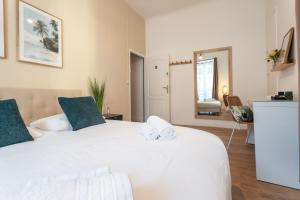 a bedroom with a large white bed with towels on it at Chambre 3 La Madalena in Nice