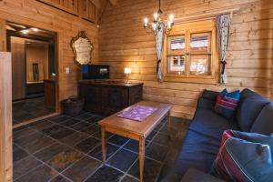 a living room with a couch and a table at Schlosswirt Chalets & Apartments in Großkirchheim
