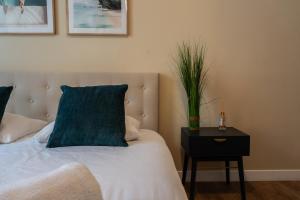 a bedroom with a bed with a blue pillow and a table at Chambre 3 La Madalena in Nice